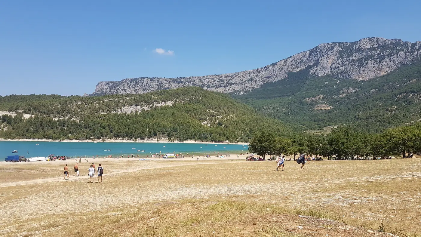 Plage de sable et baigneurs sur l'eau turquoise du lac de Sainte-Croix à Aiguines, Gorges du Verdon