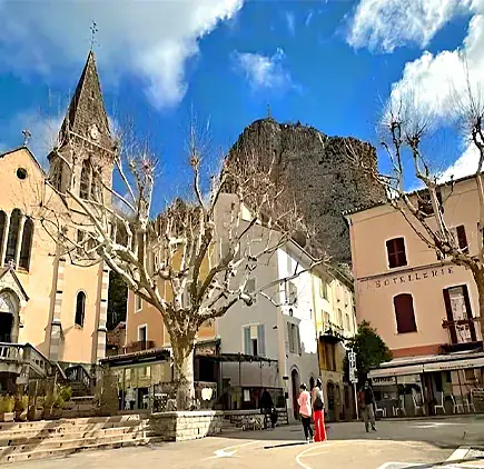 Une place du centre de Castellane, entre un clocher et le Roc