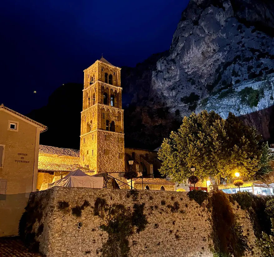 Le clocher de l’église Notre-Dame-de-l’Assomption éclairé la nuit, sous la falaise