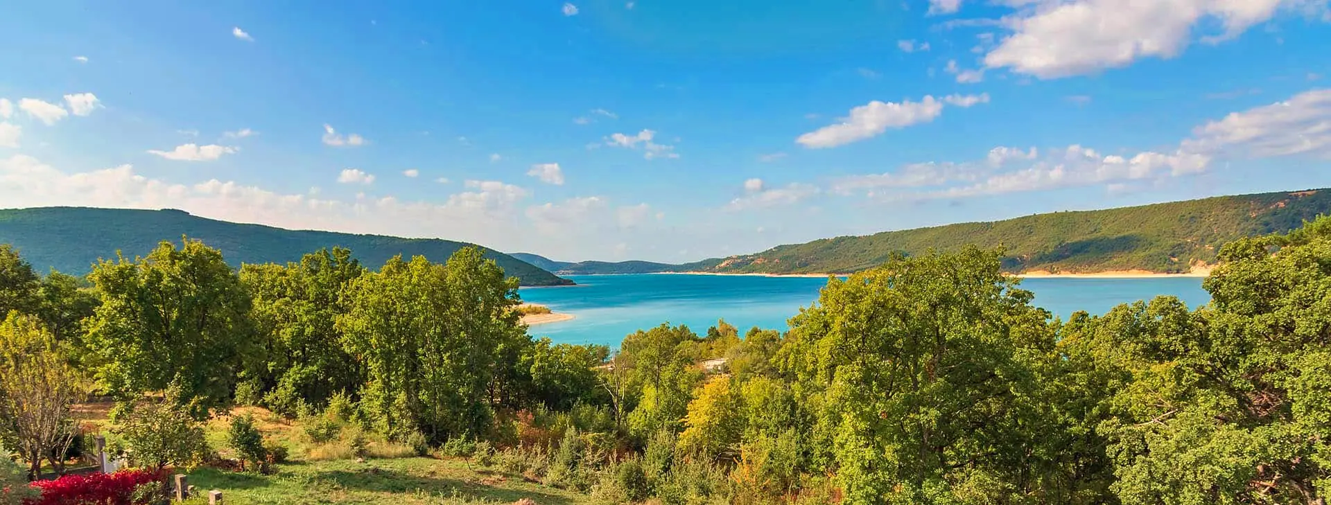 Le lac de Sainte-Croix turquoise entre les arbres, vu des Salles-sur-Verdon