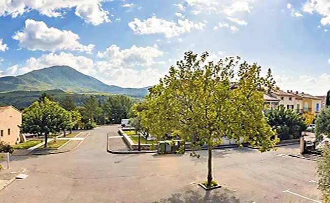La grande place des Salles-sur-Verdon, ses platanes et la montagne au loin