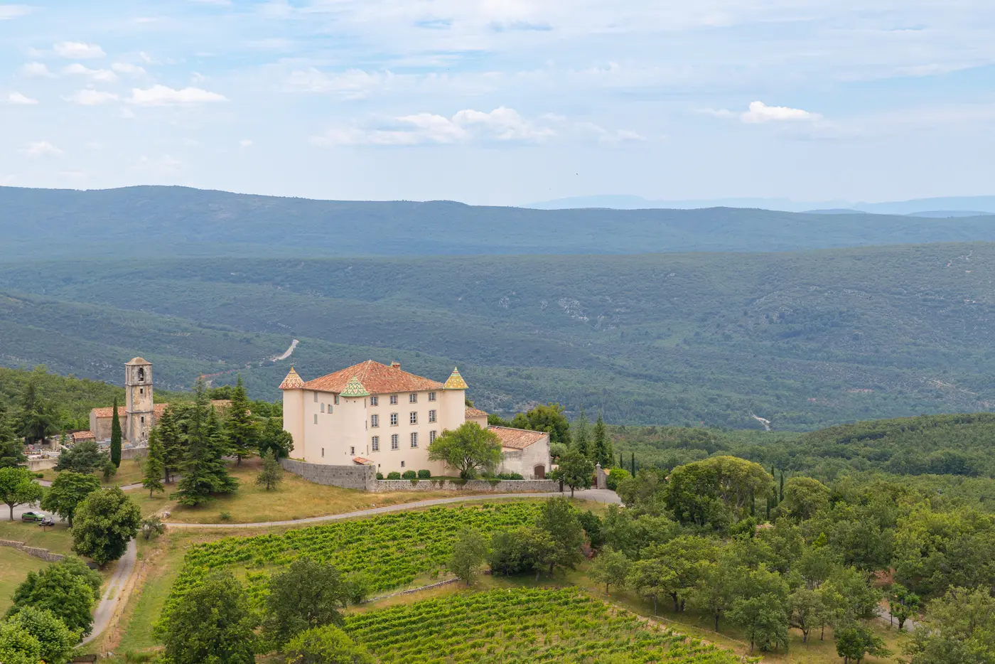 Le château Renaissance d'Aiguines et ses tourelles à tuiles vernissées, au-dessus des collines et vignes dominant le lac de Sainte-Croix, entrée ouest des Gorges du Verdon