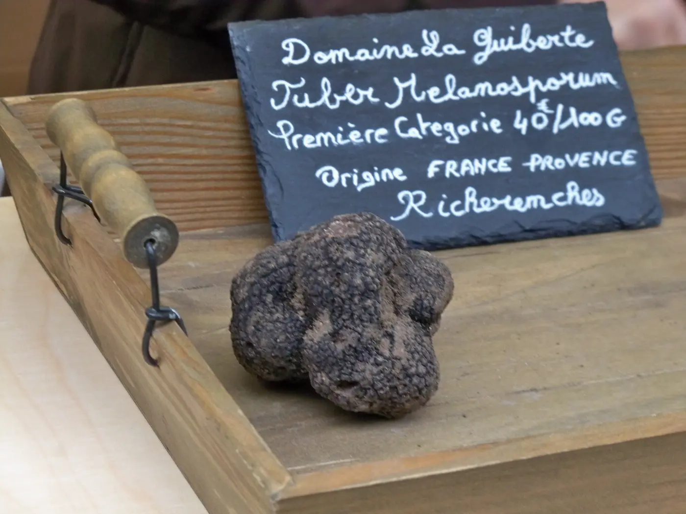 Truffe noire (Tuber melanosporum) de Provence, première catégorie, présentée sur une ardoise de marché — le « diamant noir » célébré à Aups, capitale de la truffe du Haut-Var