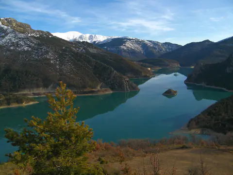 Le lac de Castillon turquoise vu de Blaron en février, avec les sommets enneigés au fond